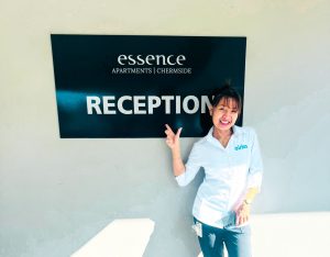 Cirka Employee in front of the Essence Hotel sign